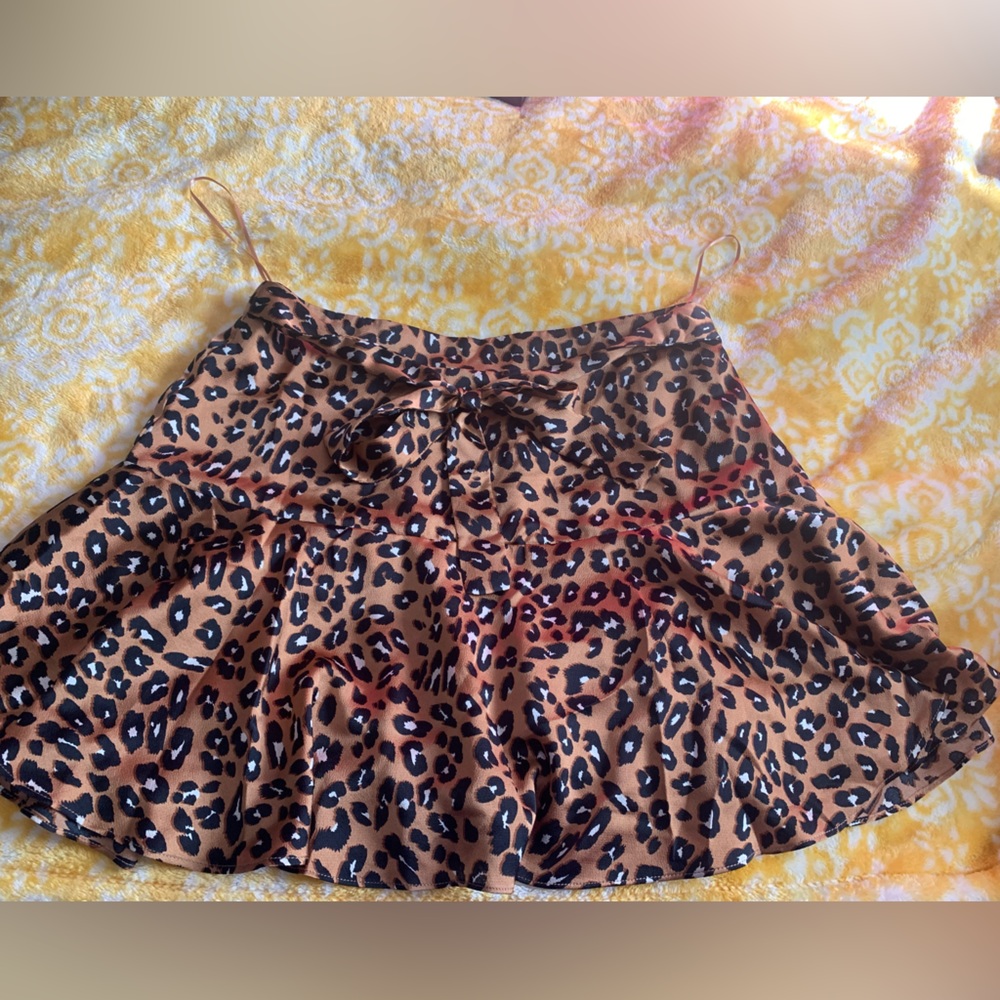 This is a brown mini skirt with leopard print all over it.